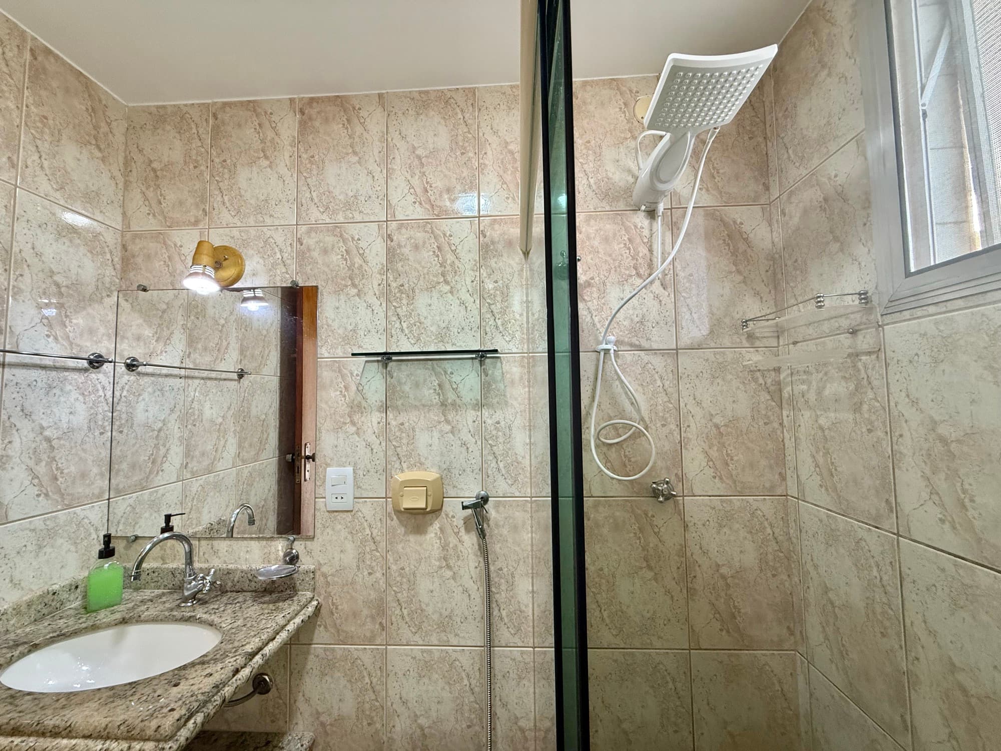 Banheiro com box de vidro e bancada de granito