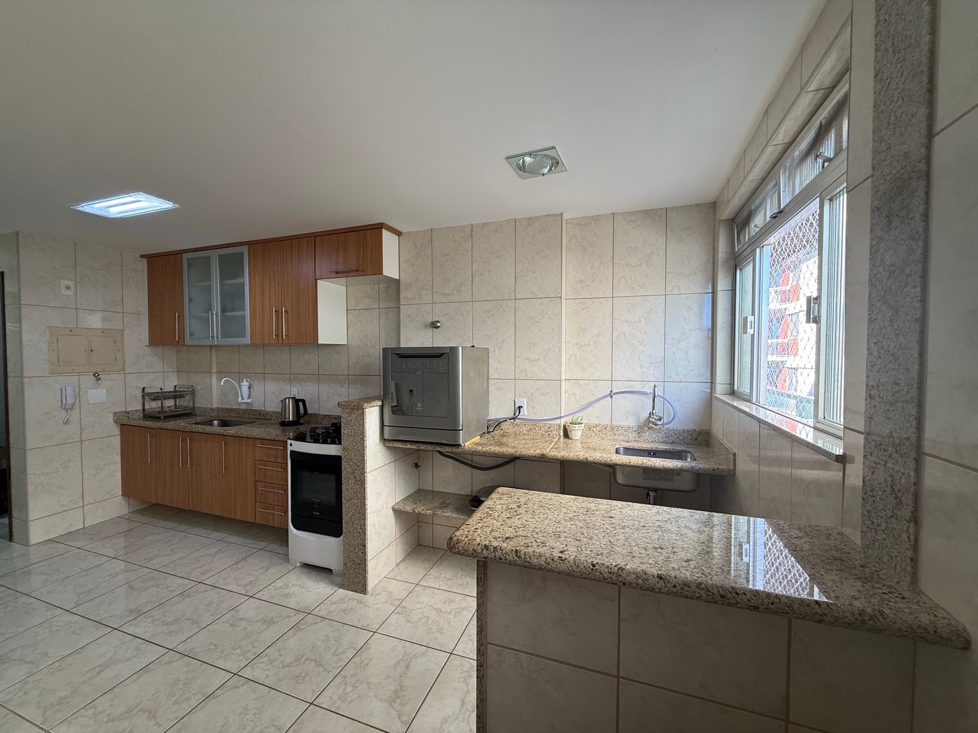Cozinha equipada com fogão, geladeira e lava-louças