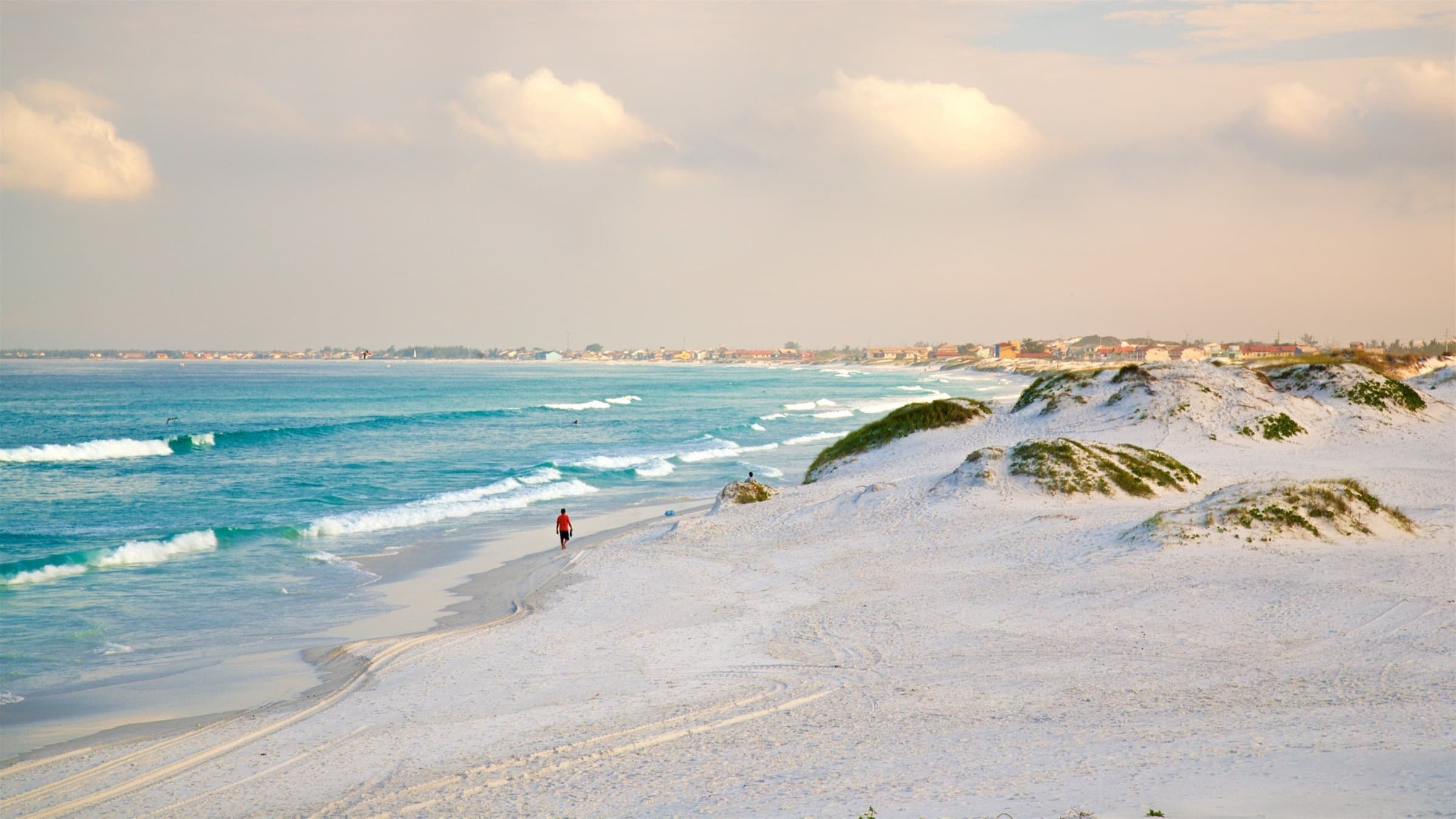 Praia das Dunas ao amanhecer, com areia branca e mar aberto